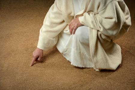 jezus schrijft in het zand met een vinger